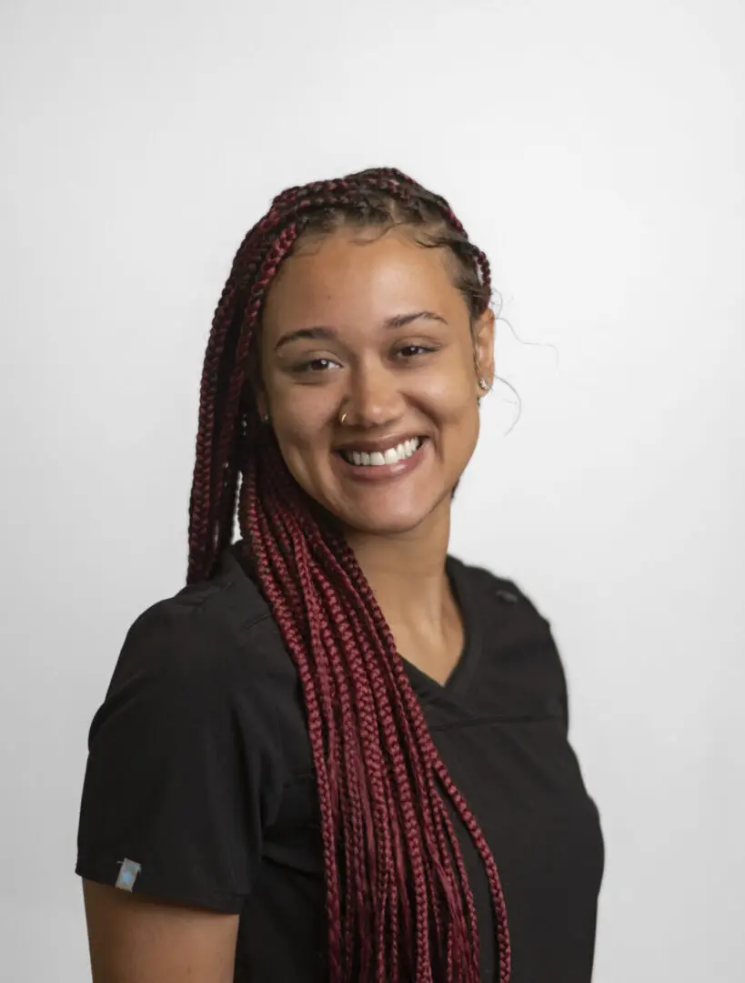 Photo-of-Jessica-Gardner-Dental-Assistant-for-Staff-Page-1165x1536 Smiling woman with braided hair, wearing black.
