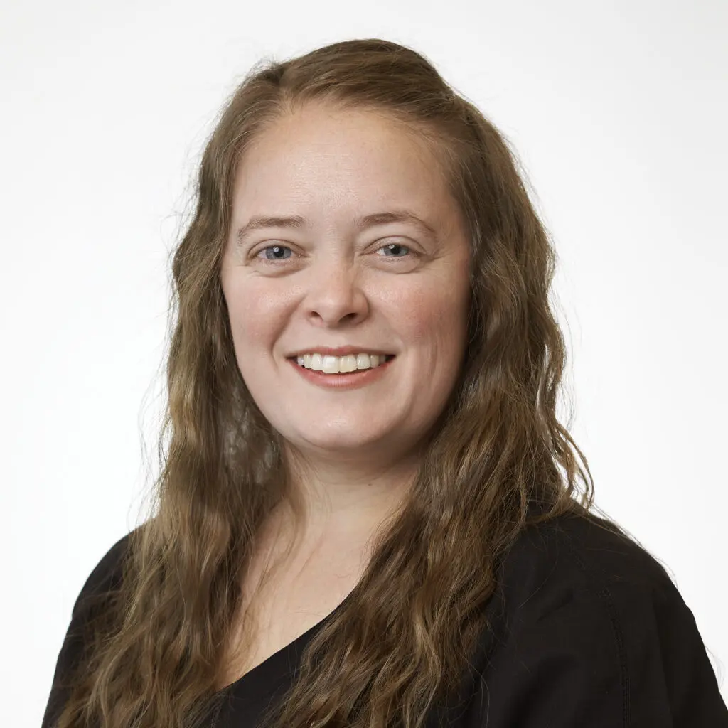 Tracy-Logan-Dental-Assistant-1024x1024 Smiling woman with long, wavy brown hair.