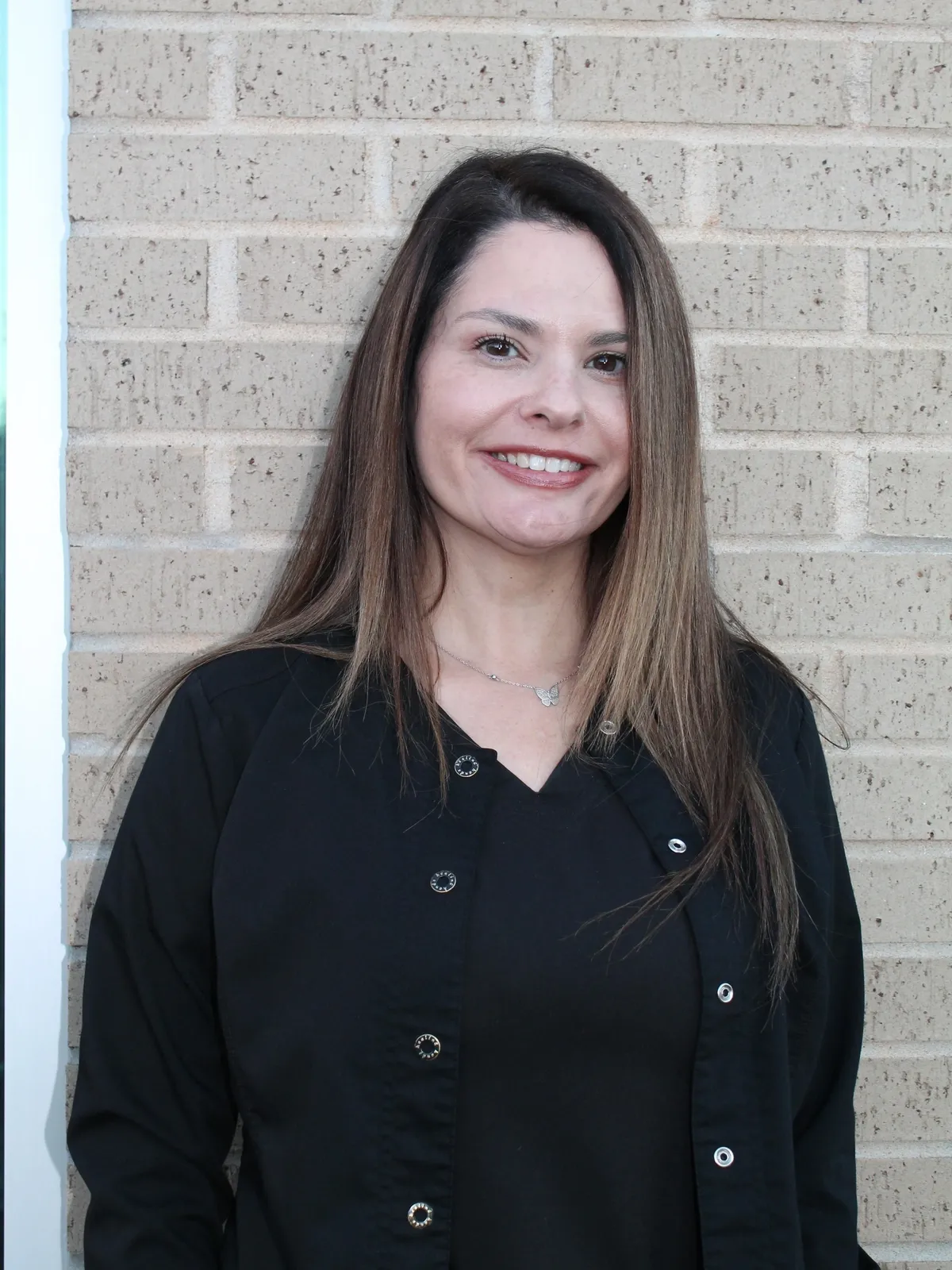 Christy Taylor A woman standing in front of a brick wall.